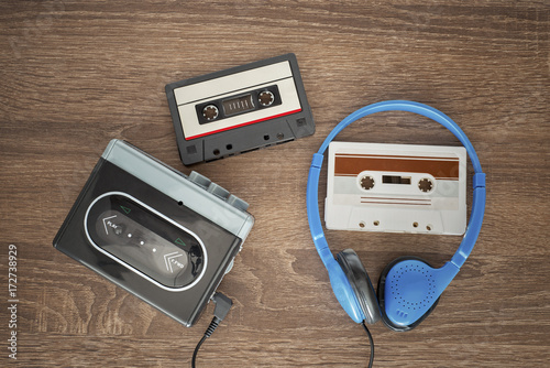 Vintage walkman, cassete and headphones on the wooden background