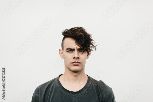 expressive portrait of man against white wall