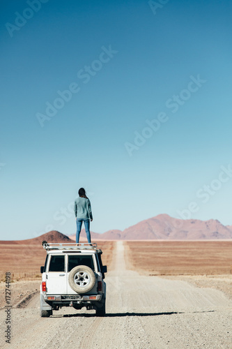 Woman on a roadtrip in an expansive empty desert photo