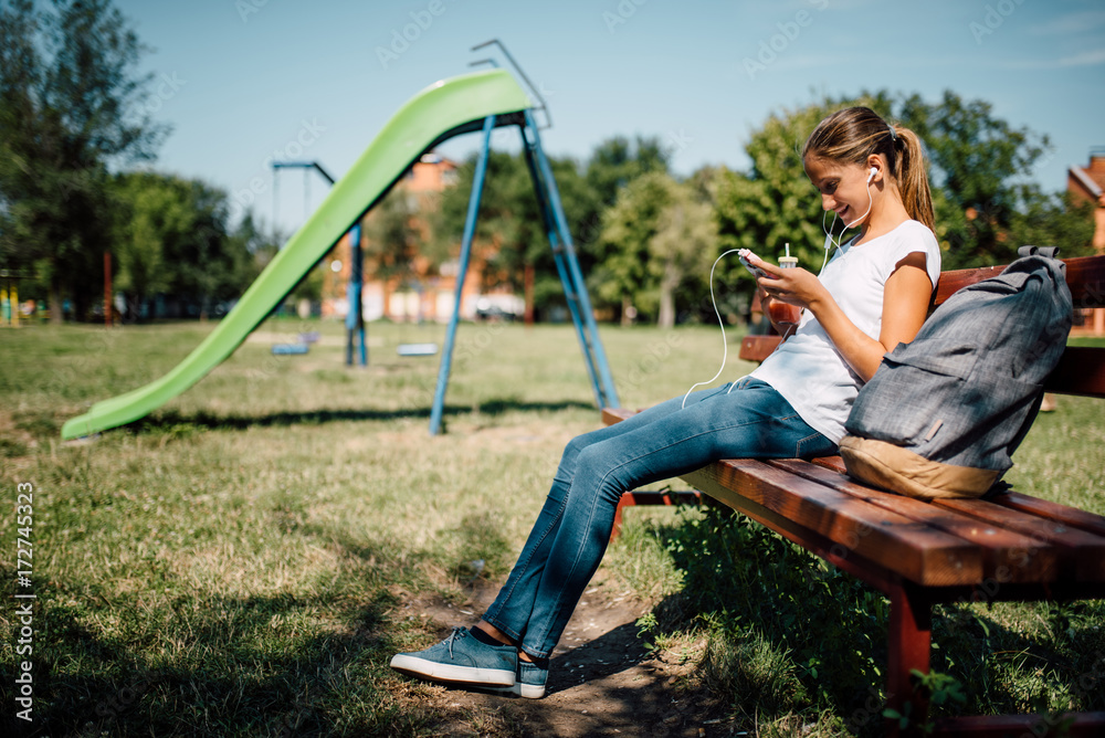Young girl sitting on the bench at the playground Young girl sitting on the bench at the playground