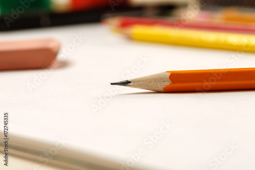 Closeup shot of pencil and eraser on a white blank sheet of paper