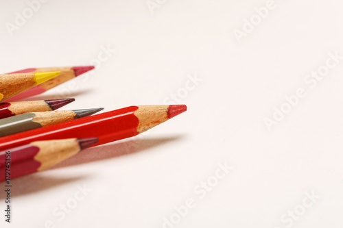 Colored pencils on a blank white sheet of paper, macro shot