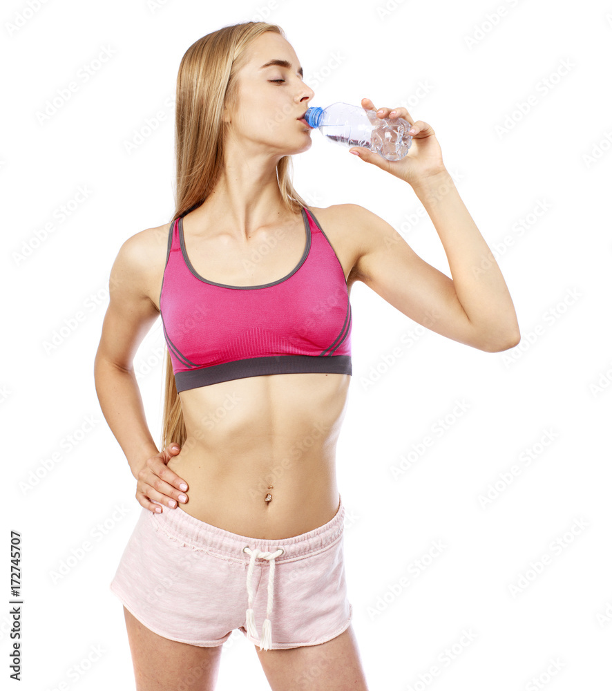 Naklejka premium Young beautiful blonde girl drinking water from a bottle