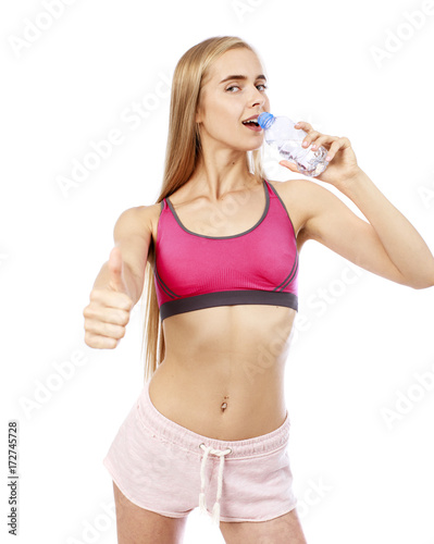 Young beautiful blonde girl drinking water from a bottle