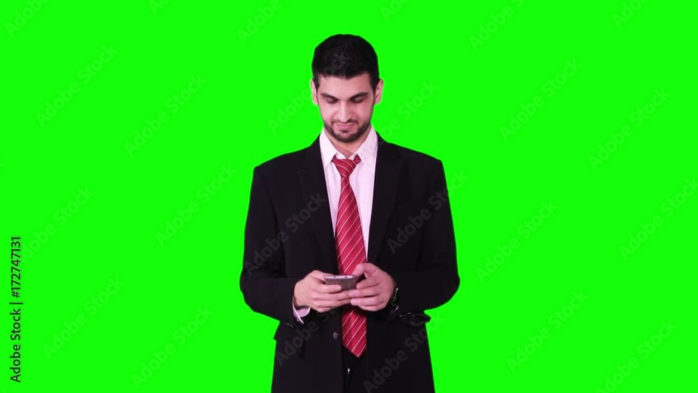 Young Caucasian businessman using cellphone and taking selfie photo in the studio while standing in front of green screen background Young Caucasian businessman using cellphone and taking selfie photo in the studio while standing in front of green screen background