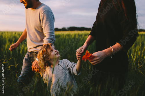 Couple with a boy walking through the barley field photo