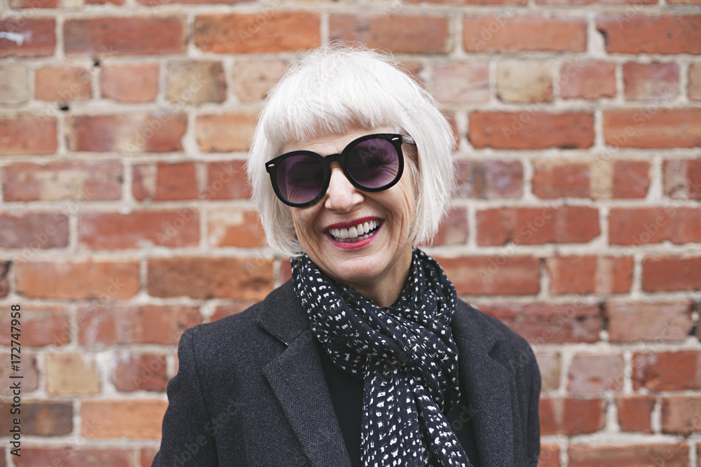 Stylish older woman wearing coat and scarf outdoors Stylish older woman wearing coat and scarf outdoors