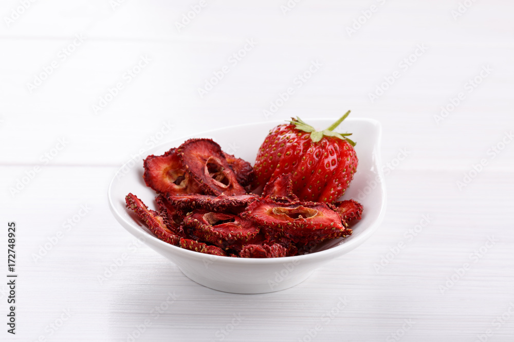 Fresh strawberry and dried strawberry slices on white wooden table. Fresh strawberry and dried strawberry slices on white wooden table.