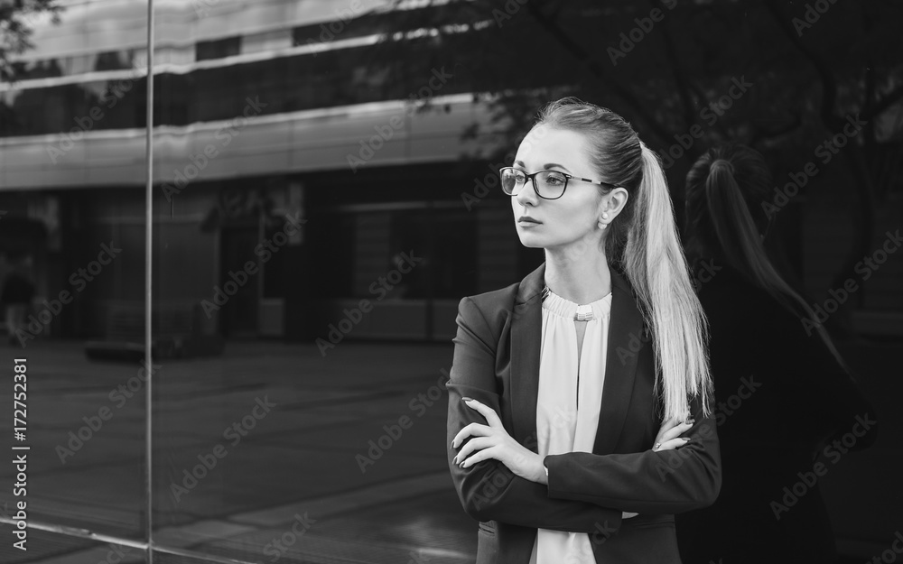 Fototapeta premium Serious young woman in suit and glasses, black and white