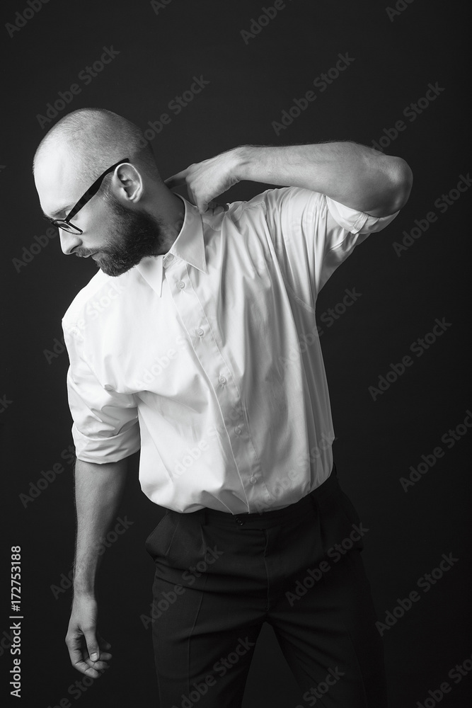 young white beard wearing glasses man white shirt black pants studio monochrome background