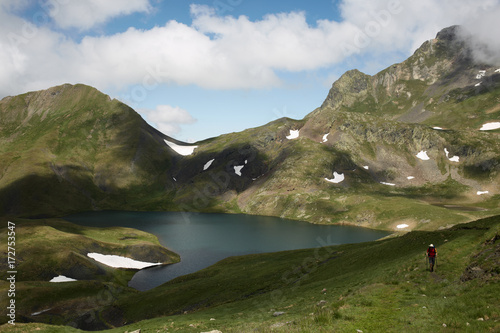 Lonely hiker in a mountain lake landscape