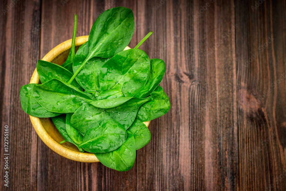 Fresh juicy spinach leaves on a wooden brown table. Natural products, greens, healthy food, vitamins. Fresh juicy spinach leaves on a wooden brown table. Natural products, greens, healthy food, vitamins.