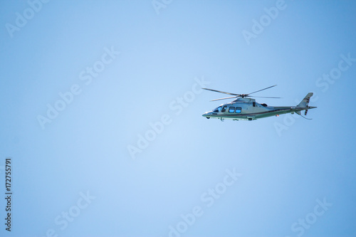 Helicopter flying in the blue sky. Blue background