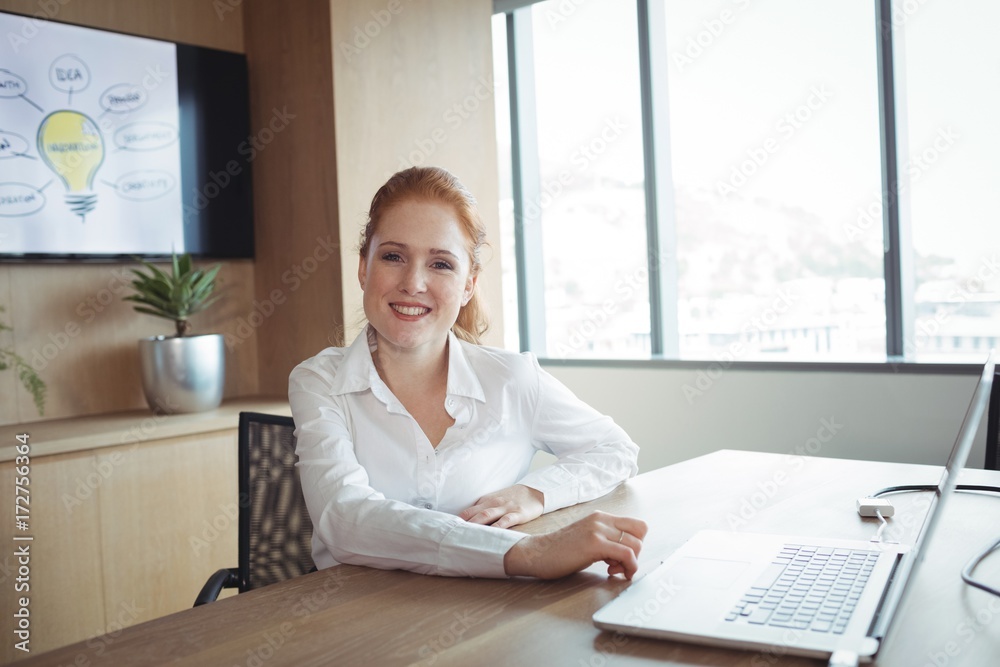 Portrait of smiling businesswoman sitting at office Portrait of smiling businesswoman sitting at office