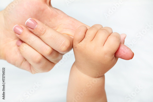 Mother holding newborn baby hand