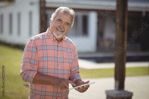 Smiling senior man using digital tablet © wavebreak3