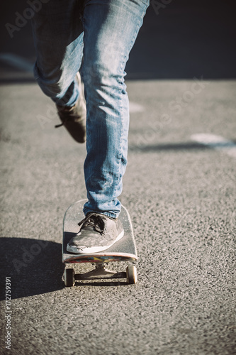 Skateboarder legs riding skateboard on the street © guruXOX