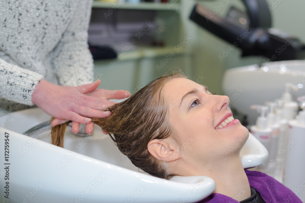 a hairdresser washing hair of a woman with shampoo a hairdresser washing hair of a woman with shampoo