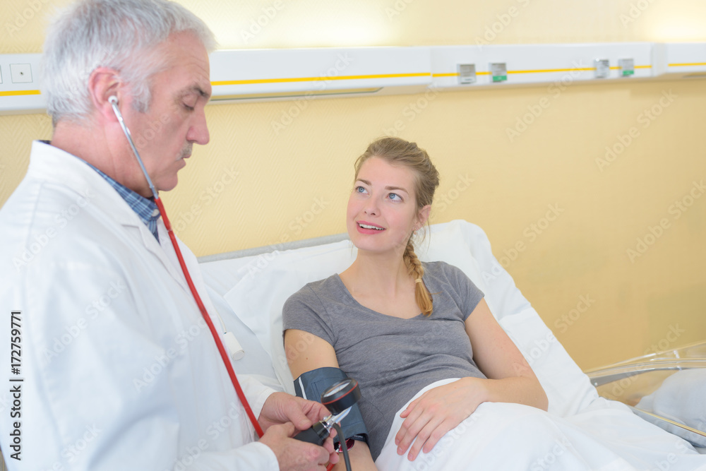 Fototapeta premium doctor man checking blood pressure cuff on woman patient