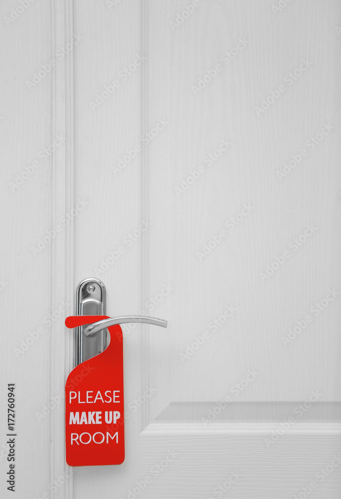 Naklejka premium Closed door with sign PLEASE MAKE UP ROOM on handle at hotel