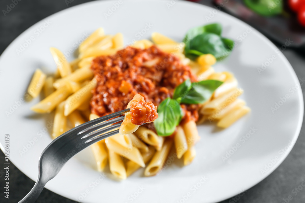 Delicious pasta with bolognese sauce on fork, closeup Delicious pasta with bolognese sauce on fork, closeup