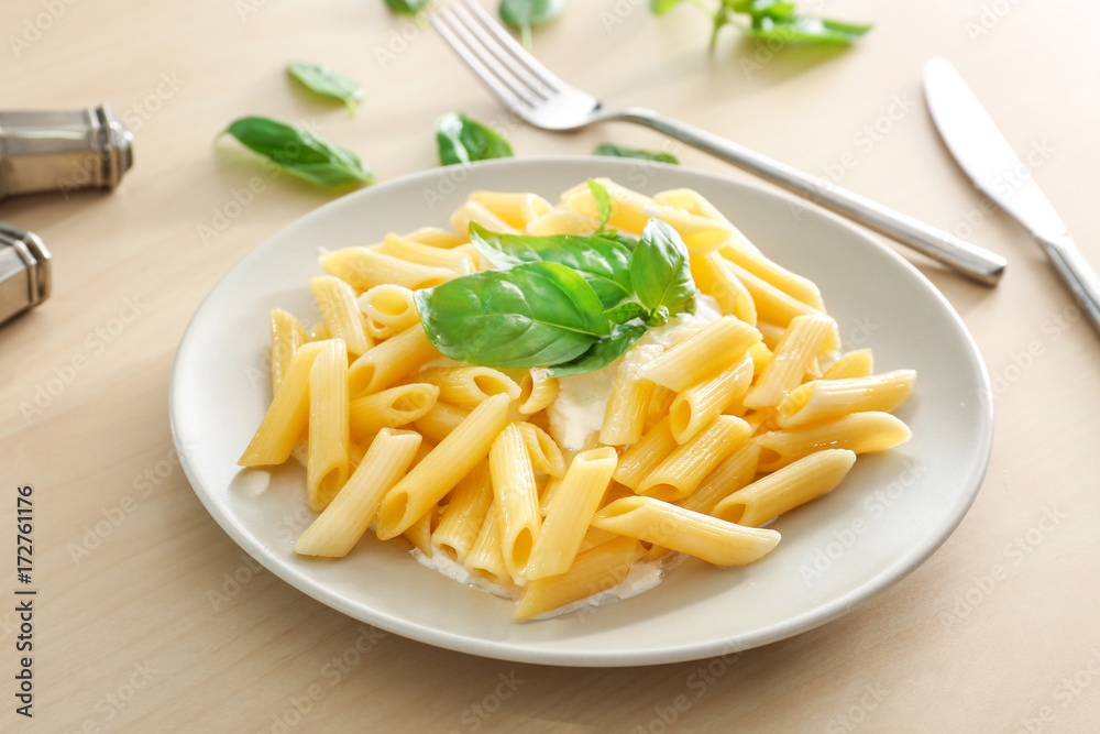 Plate of delicious pasta with white sauce on table Plate of delicious pasta with white sauce on table