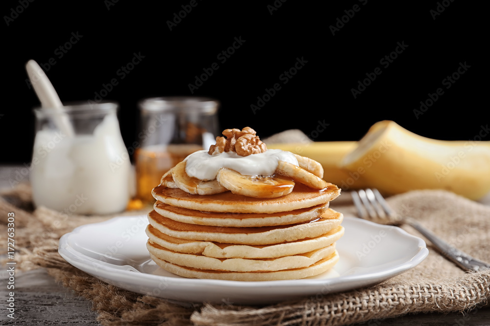 Plate with yummy banana pancakes on kitchen table Plate with yummy banana pancakes on kitchen table
