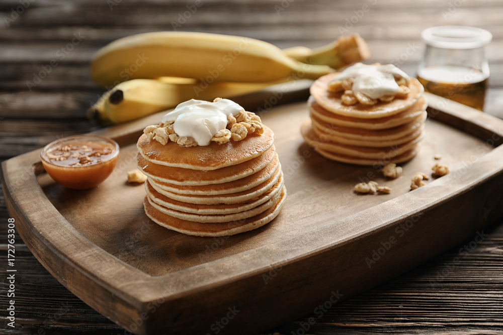 Yummy banana pancakes on wooden board