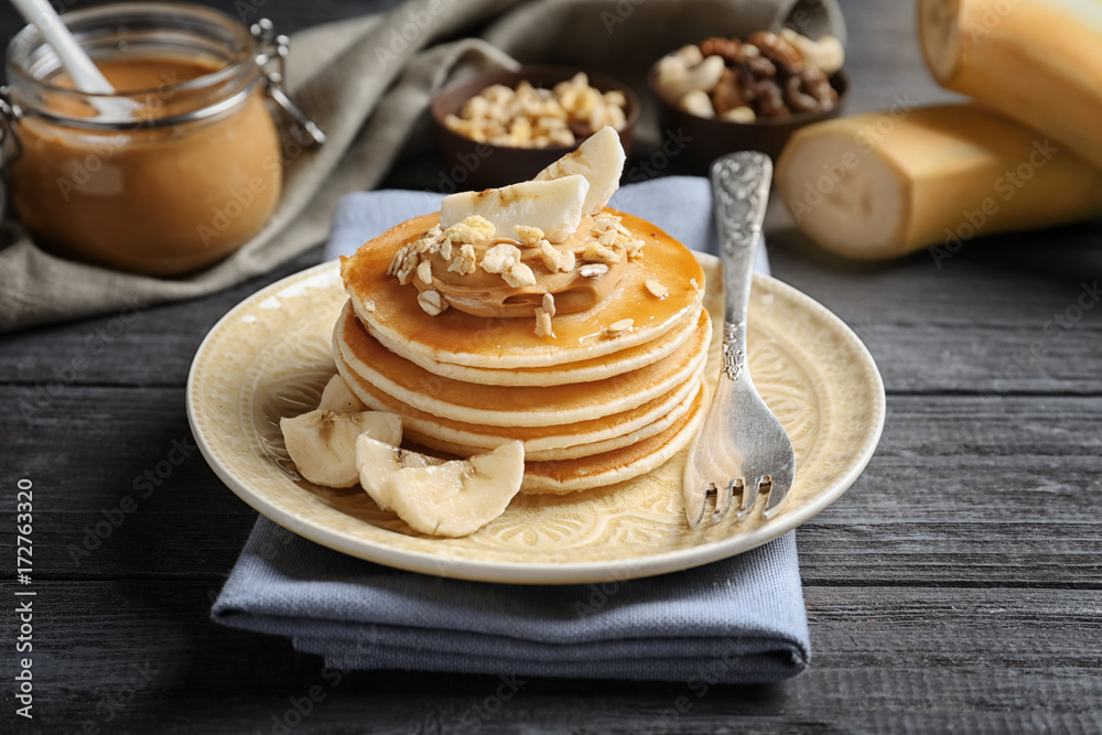 Plate with yummy banana pancakes on wooden table Plate with yummy banana pancakes on wooden table
