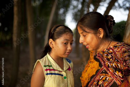 Young mother and teenage girl interacting at otdoor photo
