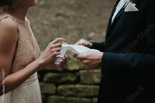 Bride and groom reading vows to each other