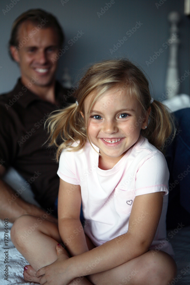 Daughter WIth Ponytails Smiling With Dad in Background Daughter WIth Ponytails Smiling With Dad in Background