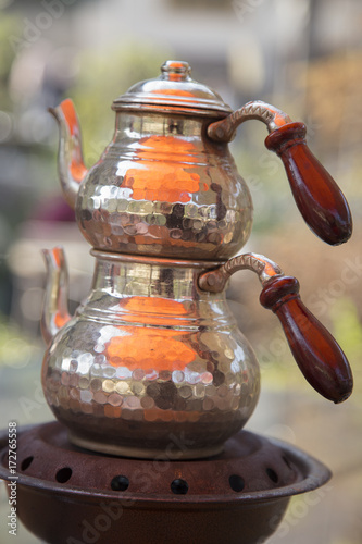 Traditional copper Turkish teapot in summer outdoor cafe. photo