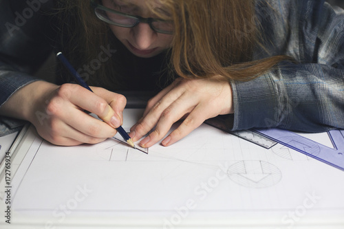 Long haired teenage boy drawing technical graphics...