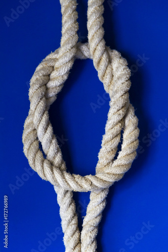 Square knot / Reef knot on the blue background. © mirkoni
