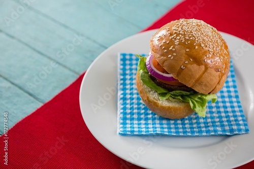 High angle view of hamburger served on napkin in plate