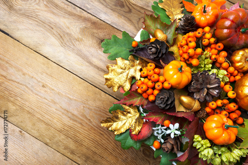 Fall arrangement with frame of pumpkins, berries and cones