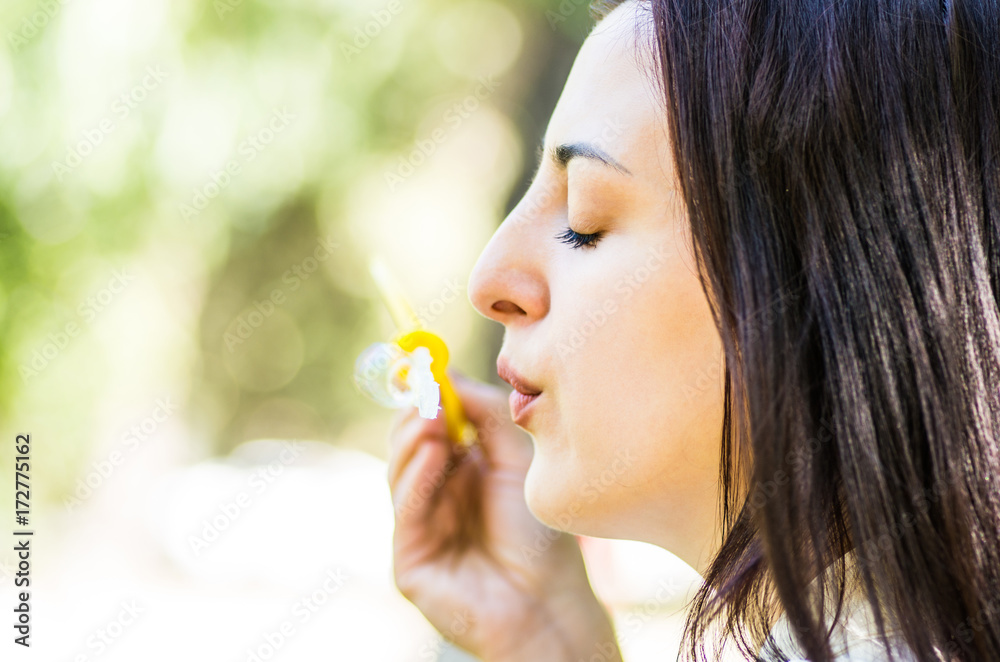 caucasian woman blowing soap bubbles in the park caucasian woman blowing soap bubbles in the park