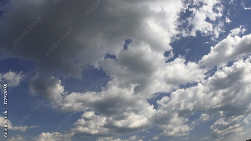 Time-lapse white fluffy clouds with dark edges move along the blue sky. Birds flit in the cloudiness. Time-lapse white fluffy clouds with dark edges move along the blue sky. Birds flit in the cloudiness.