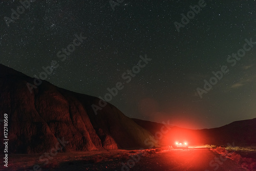 Night mountain road illuminated by headlights