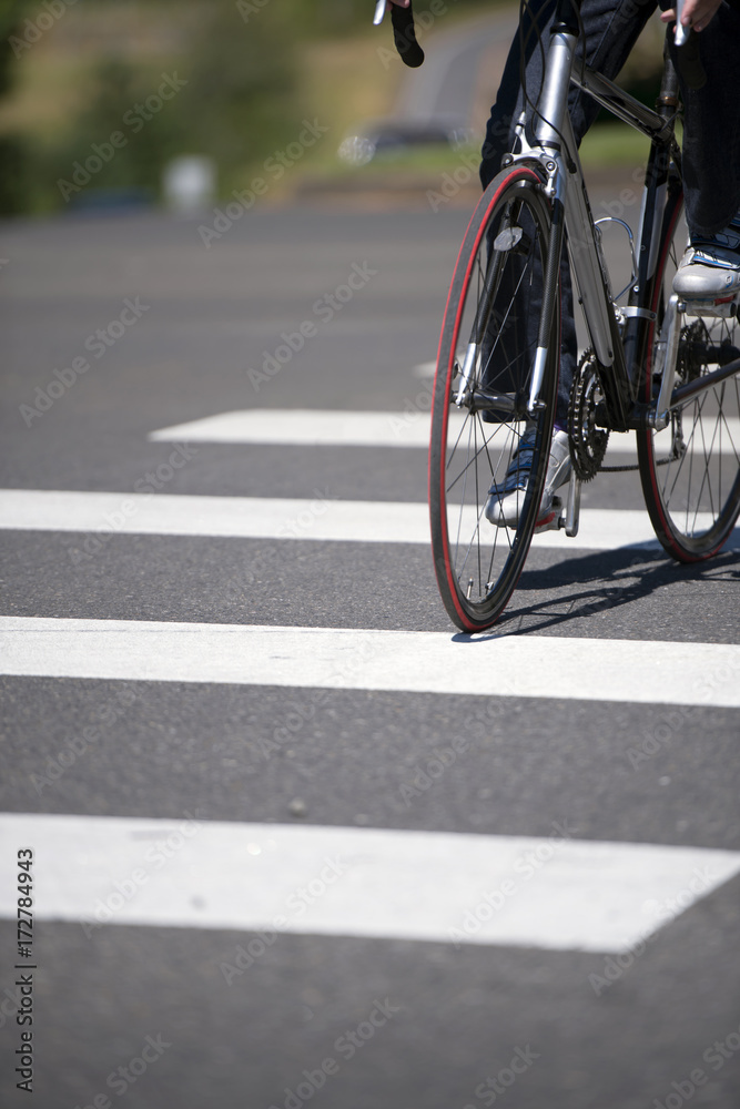 Cyclist crosses the city road with pedestrian crossing on road bike Cyclist crosses the city road with pedestrian crossing on road bike