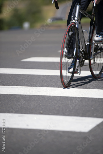 Cyclist crosses the city road with pedestrian crossing on road bike