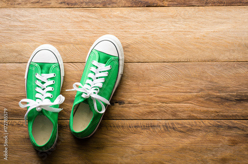 Green sneakers on wooden floors.-lifestyle