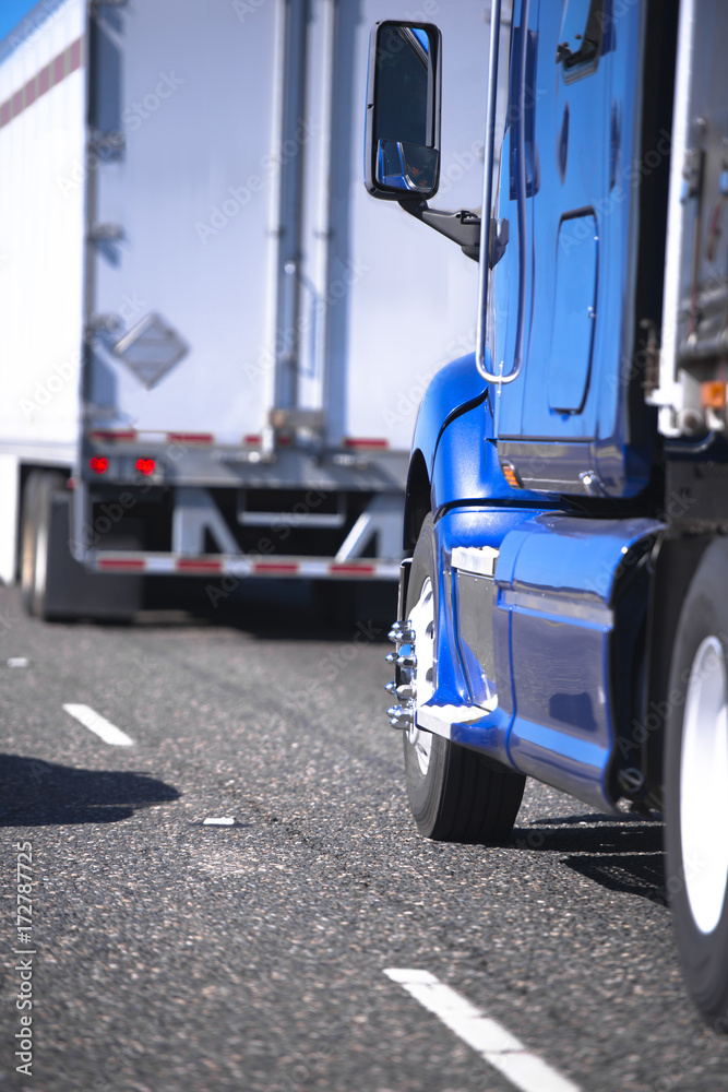 Semi trucks with trailers going in convoy on the road Semi trucks with trailers going in convoy on the road