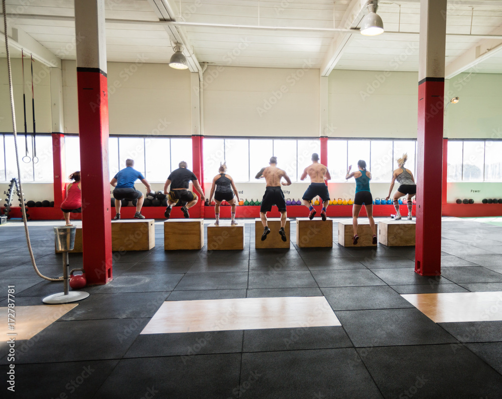 Clients Performing Box Jumps In Fitness Studio