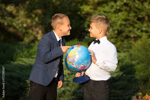 Portrait of two boys friends, school children with globes in their hands. Portrait, childhood, game.
