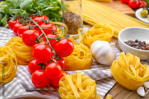 Composition with pasta nests and tomatoes on table