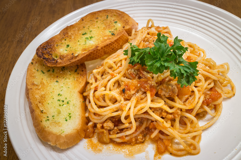 Healthy Spaghetti bolognese with garlic bread in a white dish on wood ...