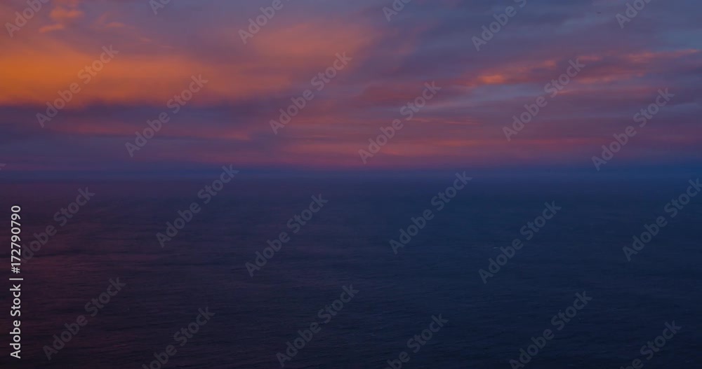 Aerial view flying over ocean with dramatic sunset lighting