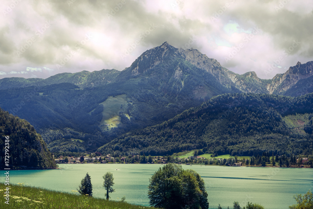 Obraz premium calm lake on a cloudy day surrounded by mountains in Alps